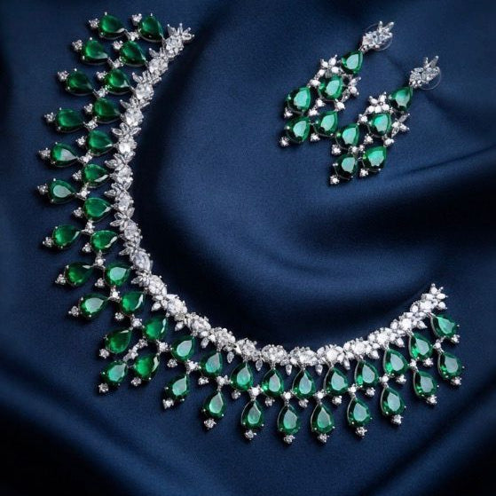 Silver-tone teardrop pendant necklace and matching drop earrings with deep blue teardrop gemstones.
